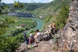 a group of people sitting on a hill overlooking a river at St Jakobshof für Moselurlaub mit Familie in Ediger-Eller