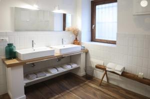 a bathroom with two sinks and towels on a shelf at Museo Grillo Camere d'Arte, dormire nel Museo in Arena Po
