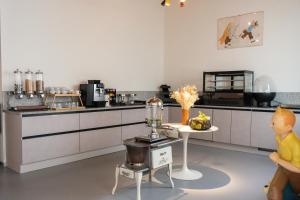 a kitchen with a table and a counter with a food appliance at Hotel Retro in Brussels