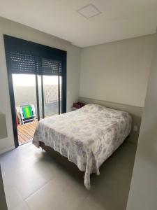 ein Schlafzimmer mit einem Bett und einem Balkon in der Unterkunft Casa na praia in Xangri-lá