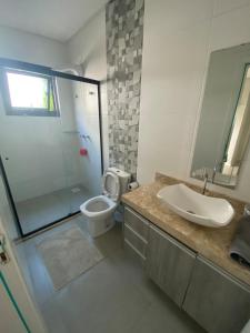 ein Badezimmer mit Toilette, Waschbecken und Dusche in der Unterkunft Casa na praia in Xangri-lá
