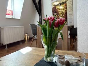 a vase of pink tulips sitting on a table at Ferienwohnung Süd in Fehmarn