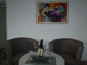 トラーベン・トラーバッハにあるFeriendomizil im Plantertのテーブル(椅子2脚付)、ワイン1本