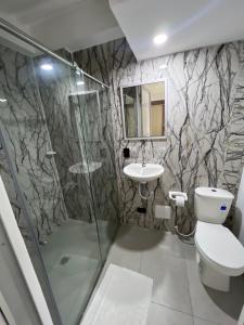 a bathroom with a shower and a toilet and a sink at Hotel Boutique Santa Ana in Cartago