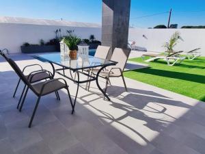 una mesa de cristal y sillas en un patio en Casa Calma, en Conil de la Frontera