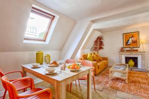 salon ze stołem i krzesłami oraz kominkiem w obiekcie L'Oasis - Chaleureux duplex - Centre Ville de Caen w Caen