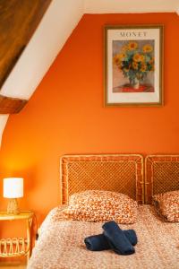 sypialnia z łóżkiem z pomarańczową ścianą w obiekcie L'Oasis - Chaleureux duplex - Centre Ville de Caen w Caen