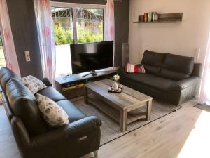 a living room with two leather couches and a television at Ferienhaus Traumspot in Wiek auf Rügen