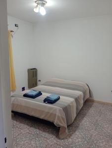 a bedroom with a bed with blue towels on it at Casa y Departamento en Centenario in Centenario