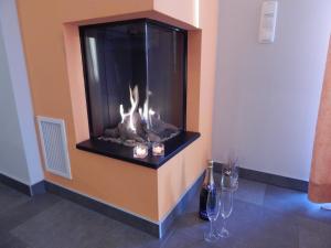 ゲーレン・レビンにあるLuxus FH "Seekiste" mit 38C Außenwhirlpoolのワイングラス付きの部屋に暖炉