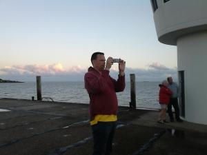 a man taking a picture of the ocean with a camera at Haus Halligblick, Ferienwohnungen am Wattenmeer, Whg Hamburger Hallig in Dagebüll +5 photos