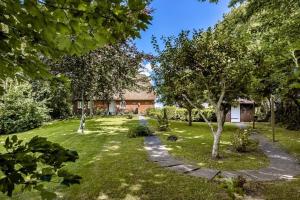 ein Garten mit einem Haus im Hintergrund in der Unterkunft Ferienhaus Katzhörn in Emmelsbüll-Horsbüll