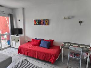 sypialnia z łóżkiem z czerwoną pościelą i stołem w obiekcie Minerva Apartments Sea View w mieście Benalmádena