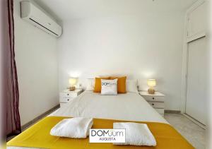 une chambre avec un grand lit avec une couverture jaune dans l'établissement DOMuum Holidays - AUGUSTA Family Home, à Salou