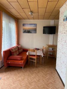 ein Wohnzimmer mit Sofa und Tisch in der Unterkunft Ferien-Bungalow Nr-3- im Seebad UeckermündeOT Bellin in Ueckermünde