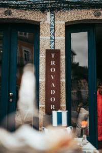 a sign for a restaurant on the side of a building at Trovador Guest House in Guimarães