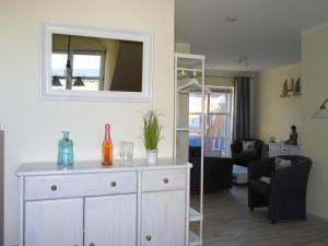 a living room with a white dresser and a mirror at Muschelkoje in Schönberg +11 photos