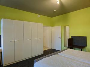 a bedroom with white cabinets and a bed and a desk at Ferienwohnung Gebauer in Görlitz