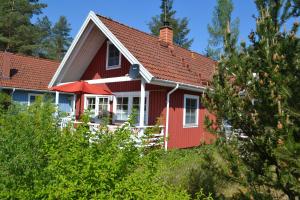 a red house with a red roof at Villa Rosenrot am See in Userin