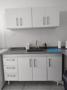 a kitchen with white cabinets and a sink at Departamento La Boca in Buenos Aires