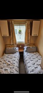 Kinmel Bayにあるellies caravan hire 8 berthの窓のある小さな部屋にベッドが2つある +3枚の写真