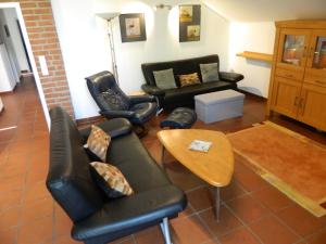a living room with black leather chairs and a table at Helle 1Obergeschosswohnung OG in Möhnesee