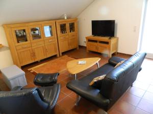 Una sala de estar con un sofá, una mesa y un televisor. en Helle 1Obergeschosswohnung OG, en Möhnesee