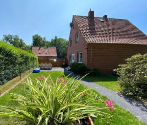 a house with a yard with pink flowers at Ferienhaus Irmgard in Bad Fallingbostel