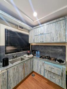 a kitchen with wooden cabinets and a sink at hotel Elites Residency , iqbal town in Lahore