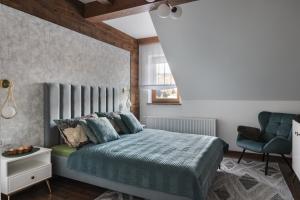 a bedroom with a bed and a chair at Apartament Berry in Waksmund +12 photos