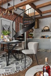 a dining room with a table and chairs and a staircase at Apartament Berry in Waksmund