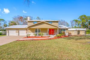 una casa amarilla con una puerta roja en un patio en The Perfect Family Retreat w Pool and Games, en West Chase