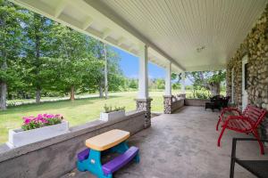een veranda met een bank en stoelen erop bij Historic 5BDR Orchard Home in Suttons Bay