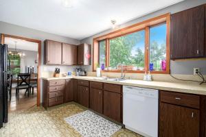 een keuken met houten kasten en een groot raam bij Historic 5BDR Orchard Home in Suttons Bay