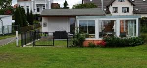 a house with a gate in the grass at Bungalow, Altwarp , Meerblick,Hund darf mit in Altwarp +15 photos