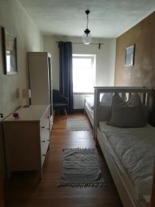 a bedroom with a bed and a dresser and a window at Ferienwohnung Storchenblick in Großwulkow