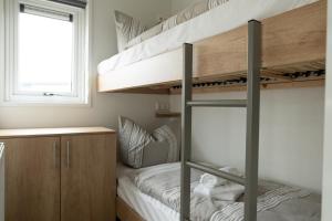 ein Schlafzimmer mit zwei Etagenbetten und einem Fenster in der Unterkunft Chalet bis sechs Personen ohne Hund - a61188 in Norden