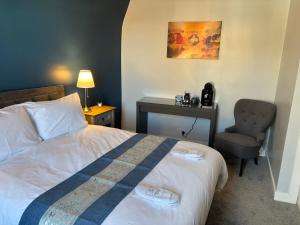 a hotel room with a bed and a chair at The Victoria Inn in Haddington