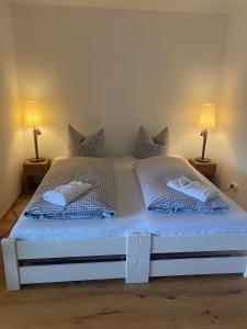a white bed with two pillows and two lamps at Appartement Raineck in Mittenwald +15 photos
