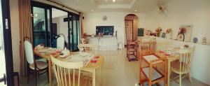 a dining room with tables and chairs in a room at Jamjuree Home at Udonthani in Udon Thani