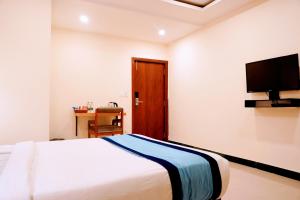 インドールにあるHotel Konark Innのベッドと薄型テレビのある寝室