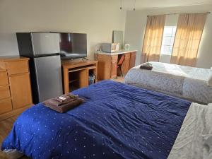 a kitchen with a refrigerator and a bed with a blue blanket at Mountaineer Motel in Mount Storm