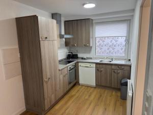 a small kitchen with wooden cabinets and a window at Ferienhaus in Soltau in Soltau