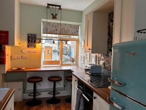 eine Küche mit einer Theke und Hockern darin in der Unterkunft Historical Village Cottage - Pet Friendly in Heysham + 21 Fotos