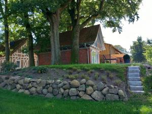 a house with a stone wall in front of a house at Ferienhaus Heidenest, E-Bike, Bettwäsche und Handtücher zubuchbar in Buchholz in der Nordheide