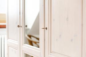a pair of white doors with a mirror at Wohnung 2 in Fehmarn