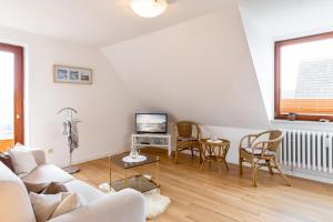 a living room with a white couch and a tv at Wohnung 2 in Fehmarn