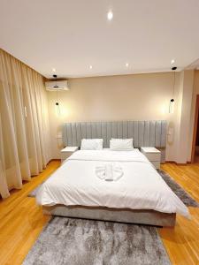 a bedroom with a large white bed with two tables at Villa Marrakech, 15 min from center, Disco, Hammam in Marrakesh