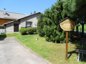 a sign in the grass in front of a house at Ferienhaus Köllner in Fischbach +7 photos