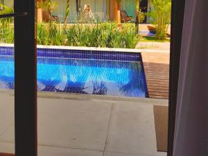 a swimming pool seen through a glass door at Pousada Sol e Mar in Maragogi